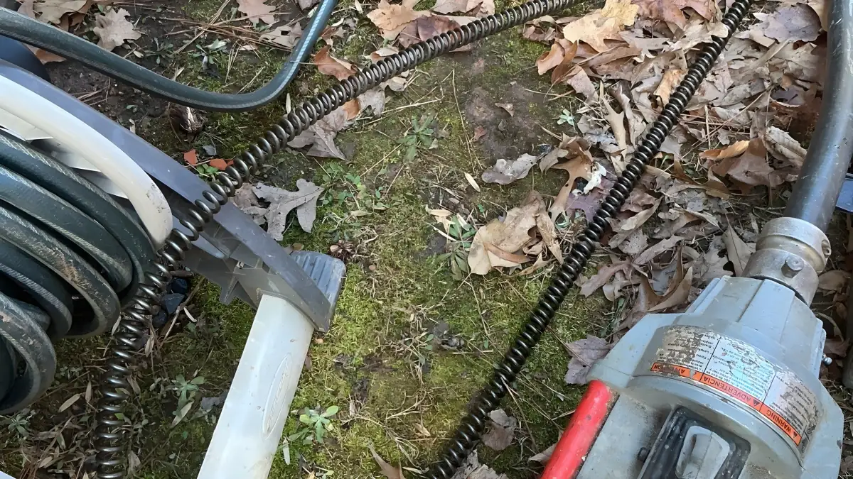 Drain cleaning machine and cables set up at the outdoor sewer cleanout.