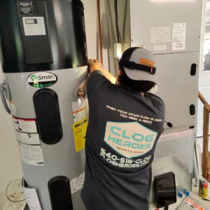 How long does it take a water heater to heat up? Clog Heroes technician inspecting a residential water heater during a service call