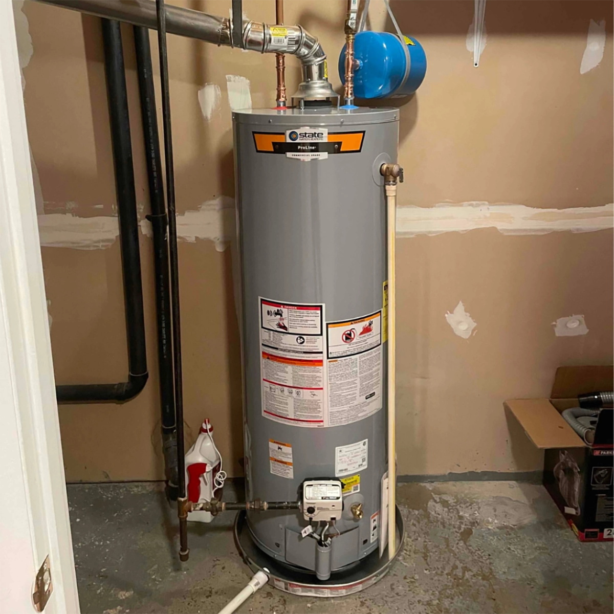 How to drain a water heater safely — residential gas water heater with blue expansion tank in a utility room