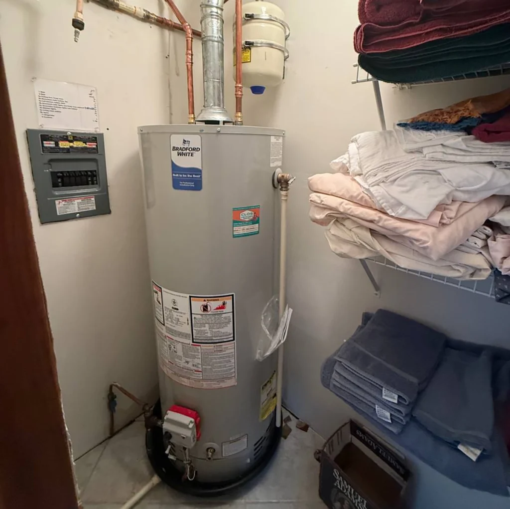How to turn off water heater system showing the gas control, cold-water shutoff valve, and expansion tank in a residential setup.