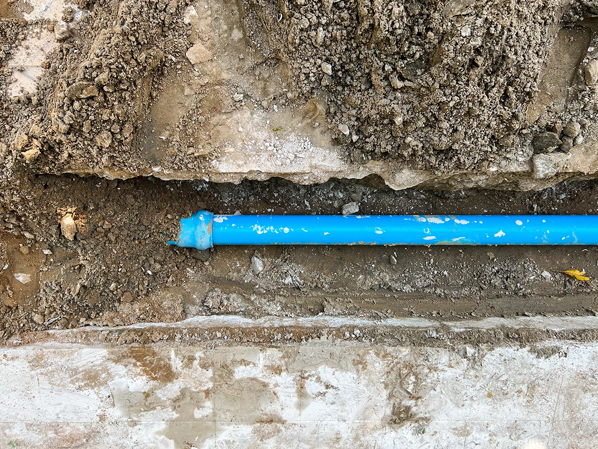 Clog Heroes - What Is a Water Line and How Does It Work? Underground residential water line made of blue PVC installed in a trench.