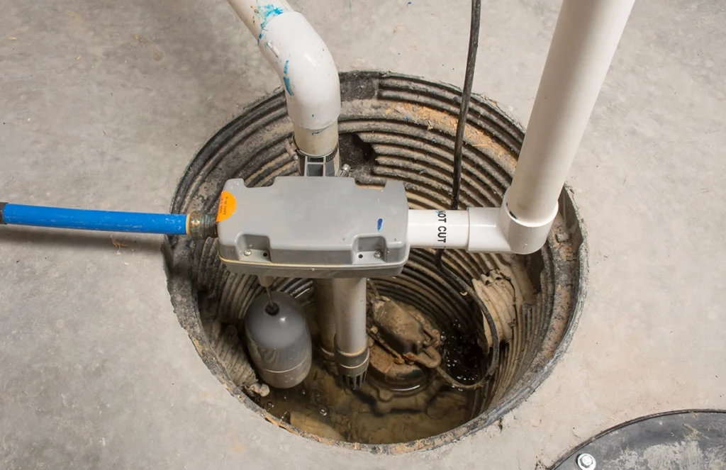 Sewer backup alarm system setup in a basement pit with float switch and plumbing