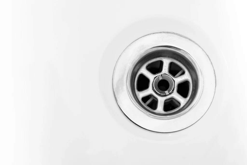 Close-up of a clean bathroom sink drain, representing how to unclog bathroom sink problems and prevent common drain blockages
