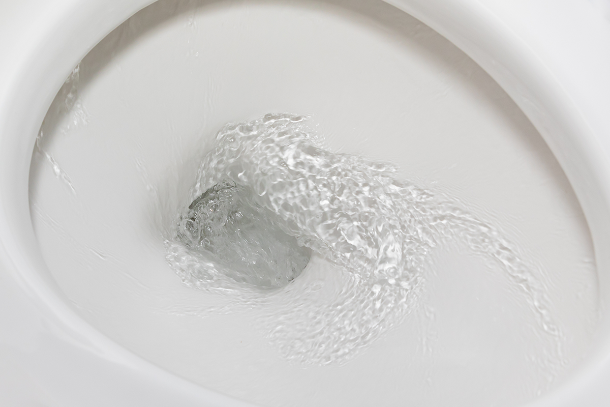 Plumber for running toilet issues shown by water continuously flowing inside a toilet bowl