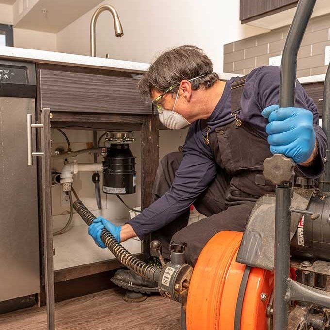 Technician Conductung Drain Cleaning Services
